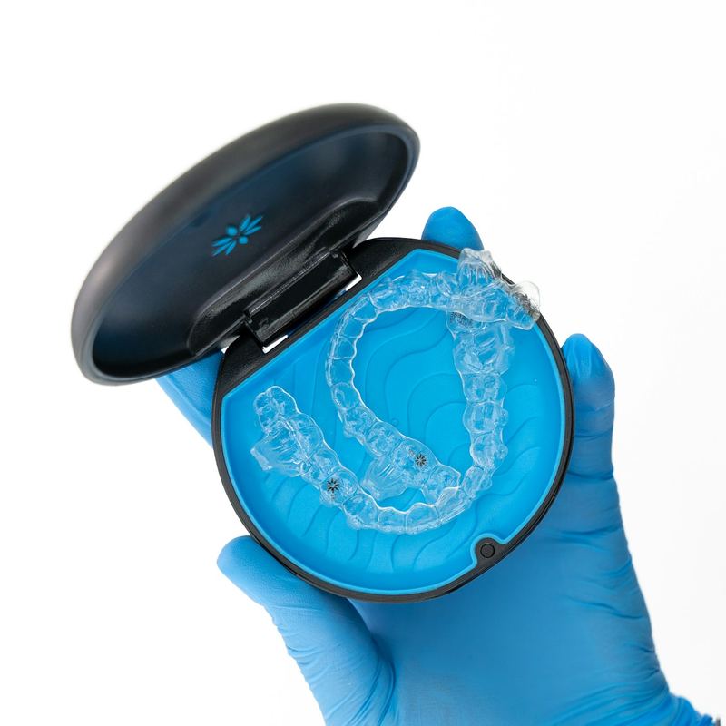 A clear aligner tray in its travel case